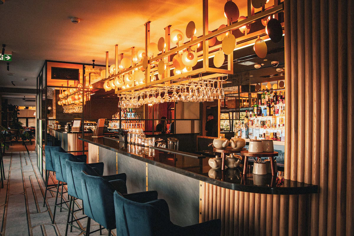 Bar and dining area at Hotel MDM with warm brass lighting